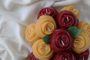 pure beeswax red rose and natural candles used as a wedding bouquet on white sheet